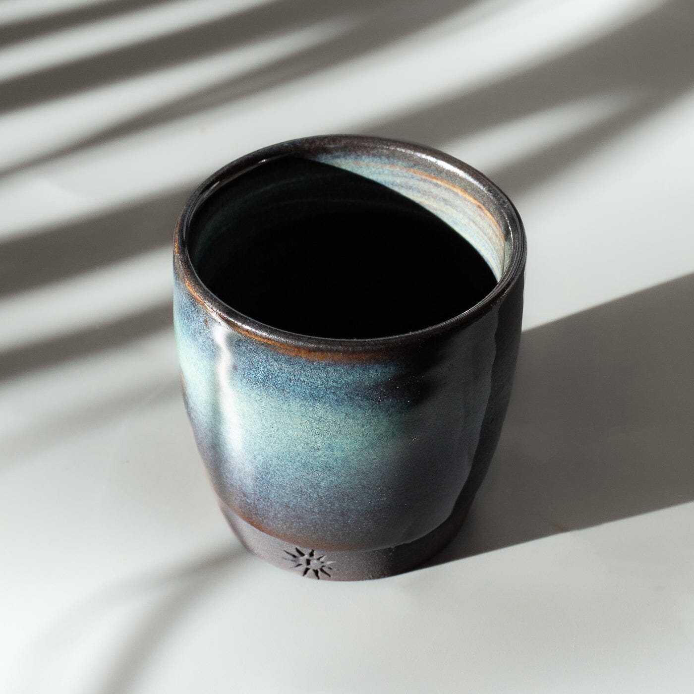 Black stoneware clay espresso cup. Turquoise glaze.